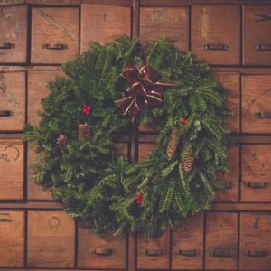 A festive wreath set against a wooden background.