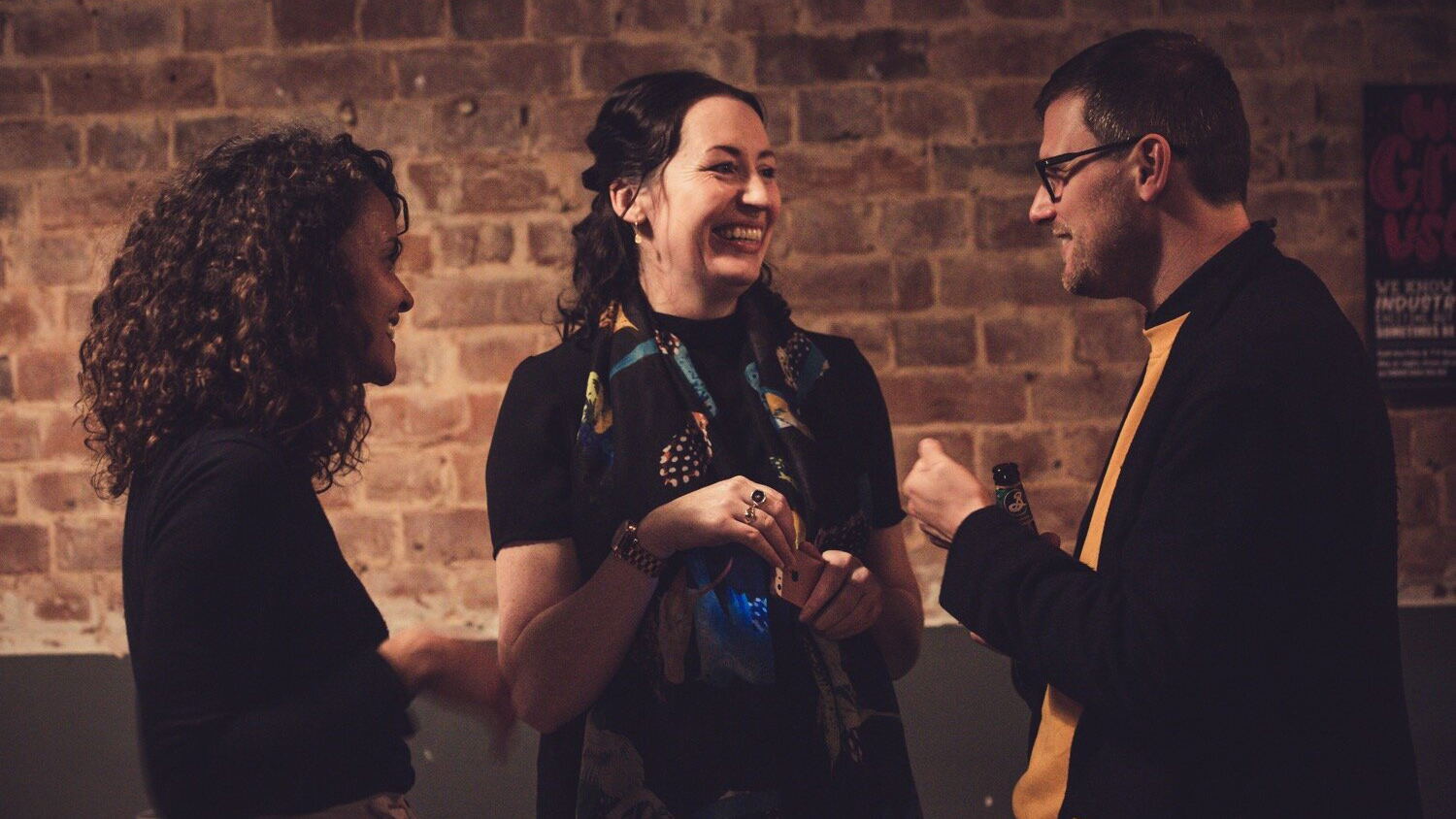 Three people smiling and talking