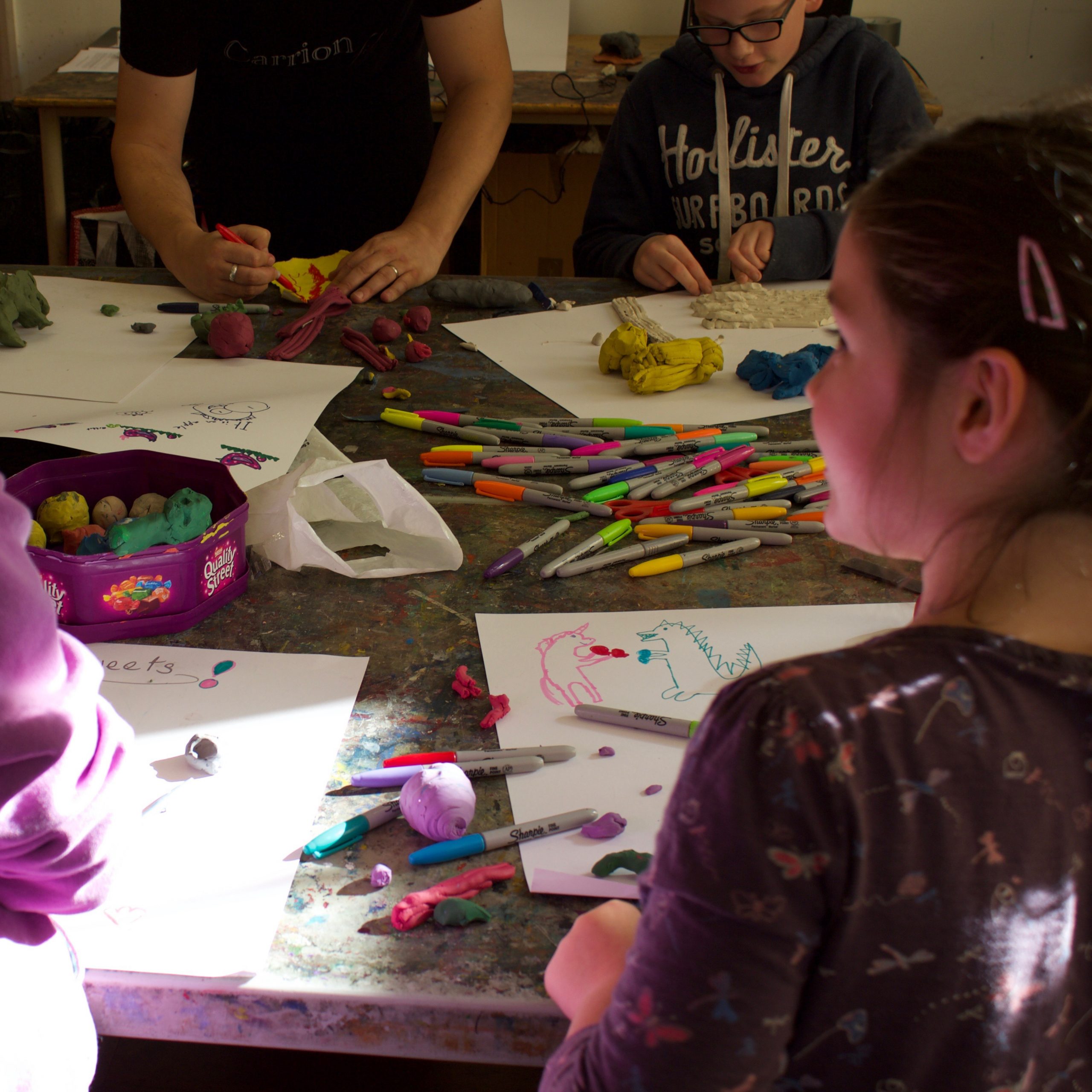 A group of young people make plasticine models