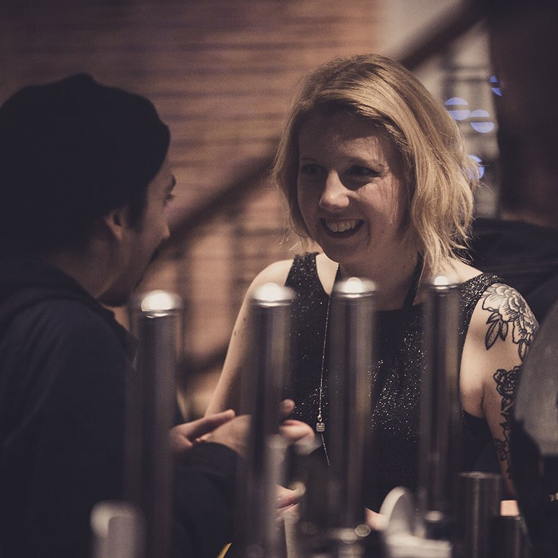 An image of a woman ordering a drink at the bar