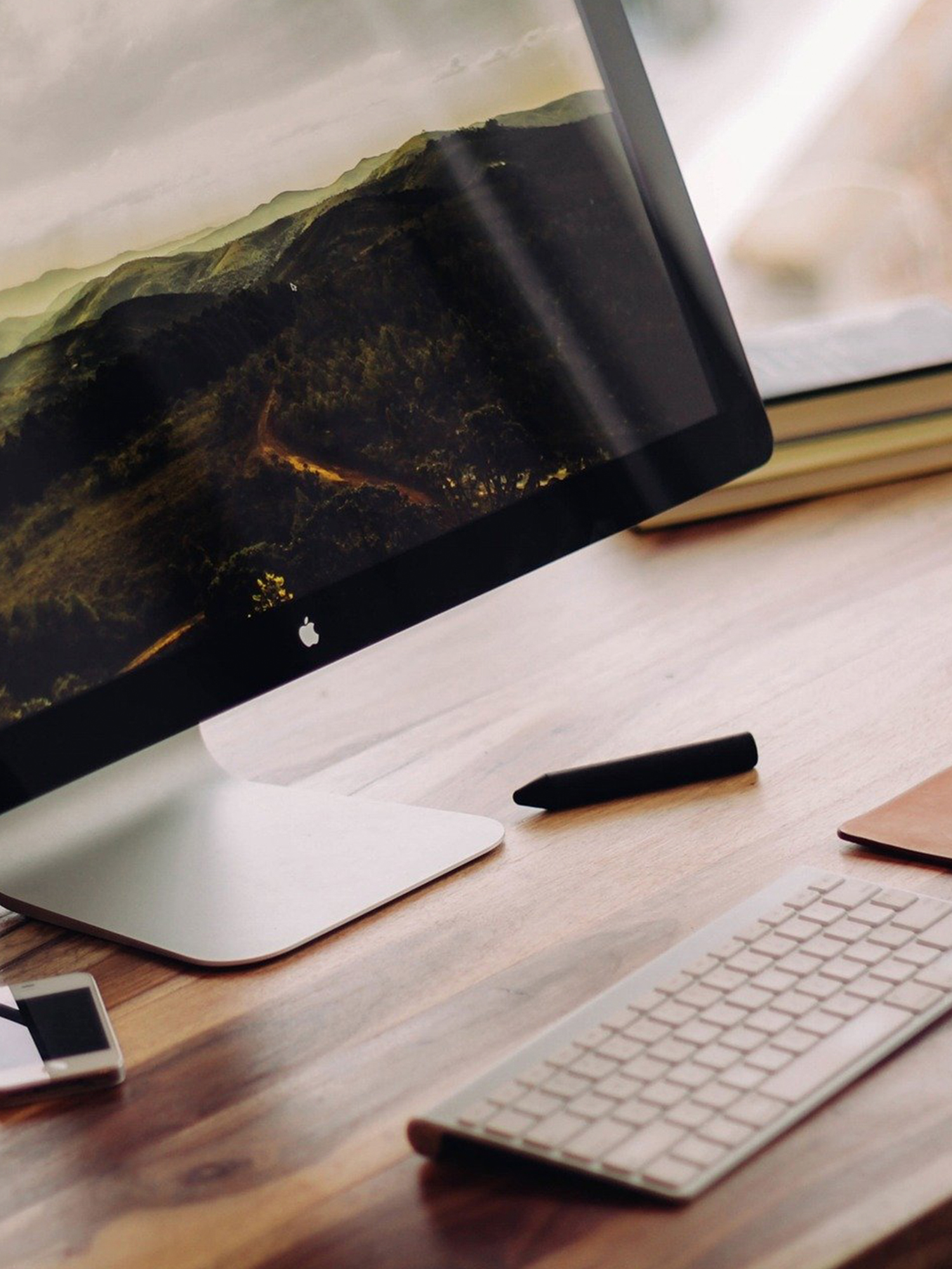 A close up of a Mac computer at a shiny desk.