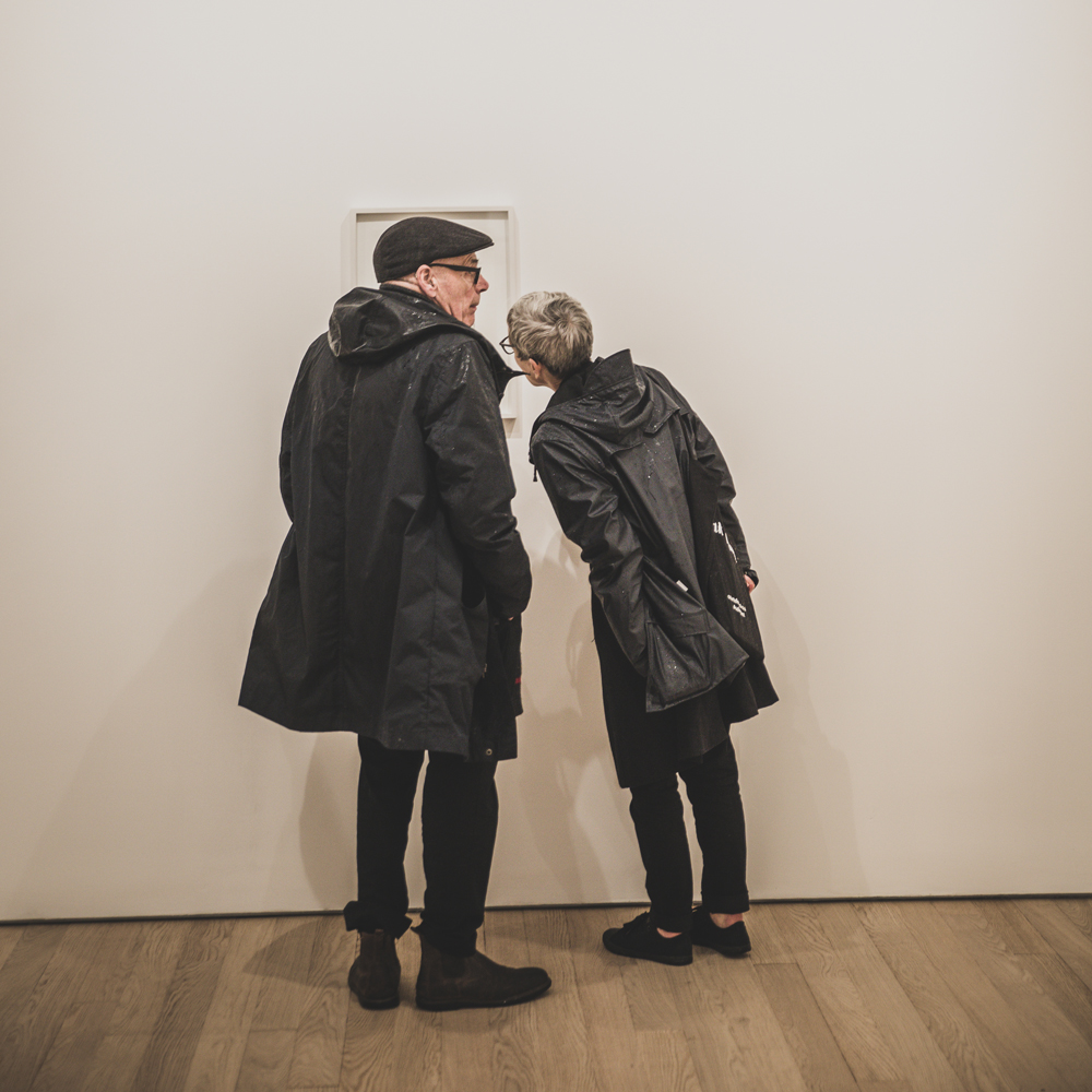 Photo of two people looking at a framed photo in a gallery