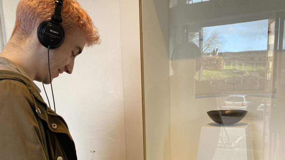 A man looks at an exhibition in a small gallery window