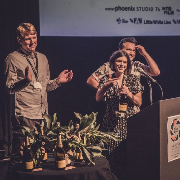Our film team Claire, Jonas and Luke presenting awards from a podium on our stage at Two Short Nights film festival