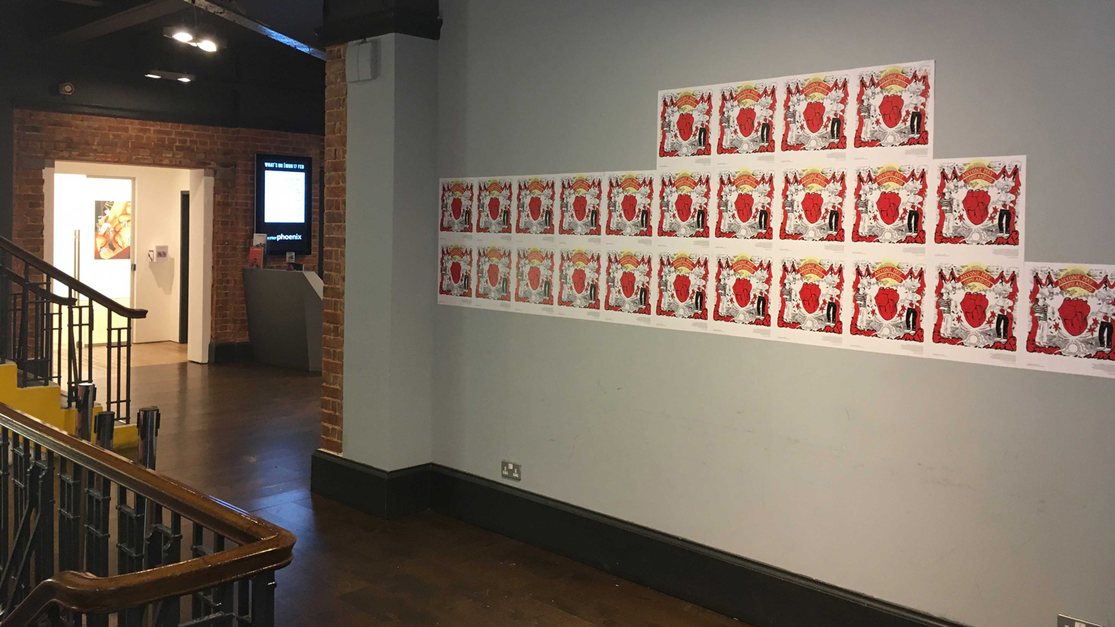 An exhibtion featuring red posters on a grey wall