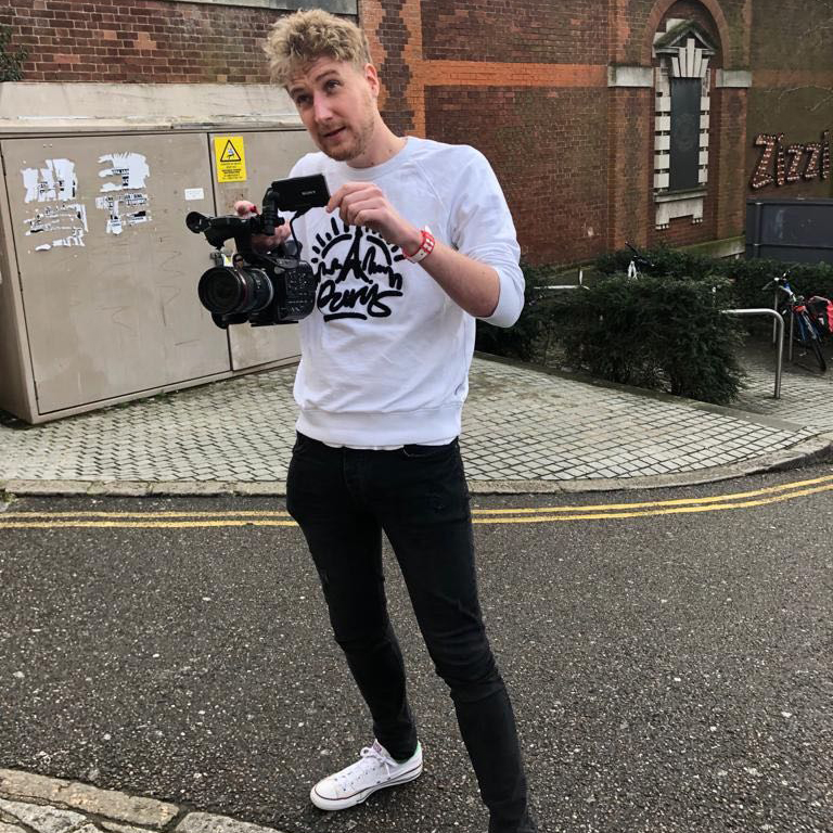 filmmaker A man films with a camera in front of Exeter Phoenix