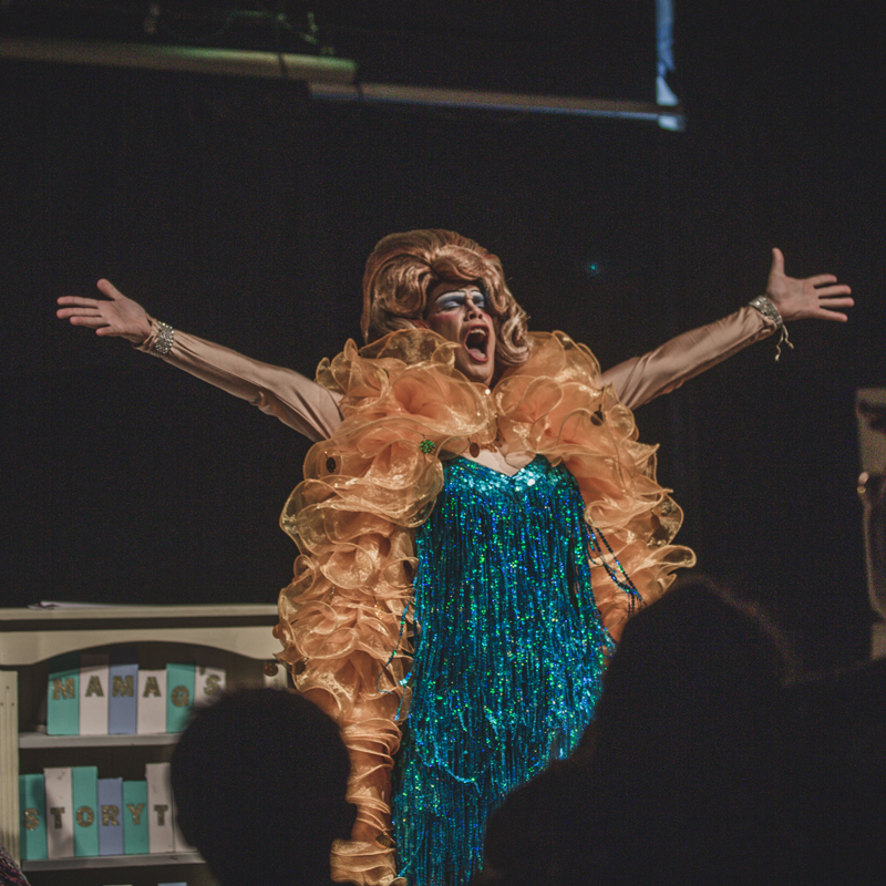 Drag performer mama g takes to the stage in a feather boa and sequinned gown