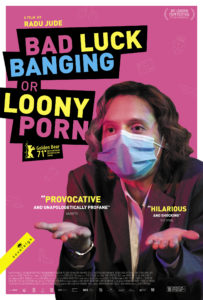 Bad Luck Banging or Loony Porn poster - Bright pink background with main character stood shrugging her shoulders at the camera with a face mask on