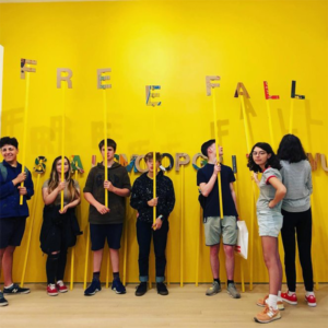 Young people using letters on sticks to spell 'FREEFALL'