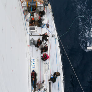 A crew on a sail boat, taken from on top of the sail