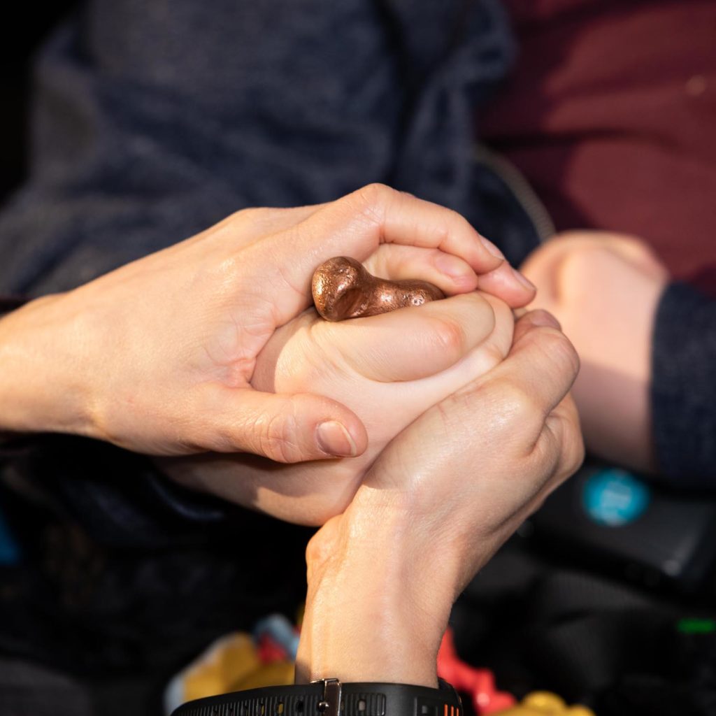 A cast object being held by multiple hands