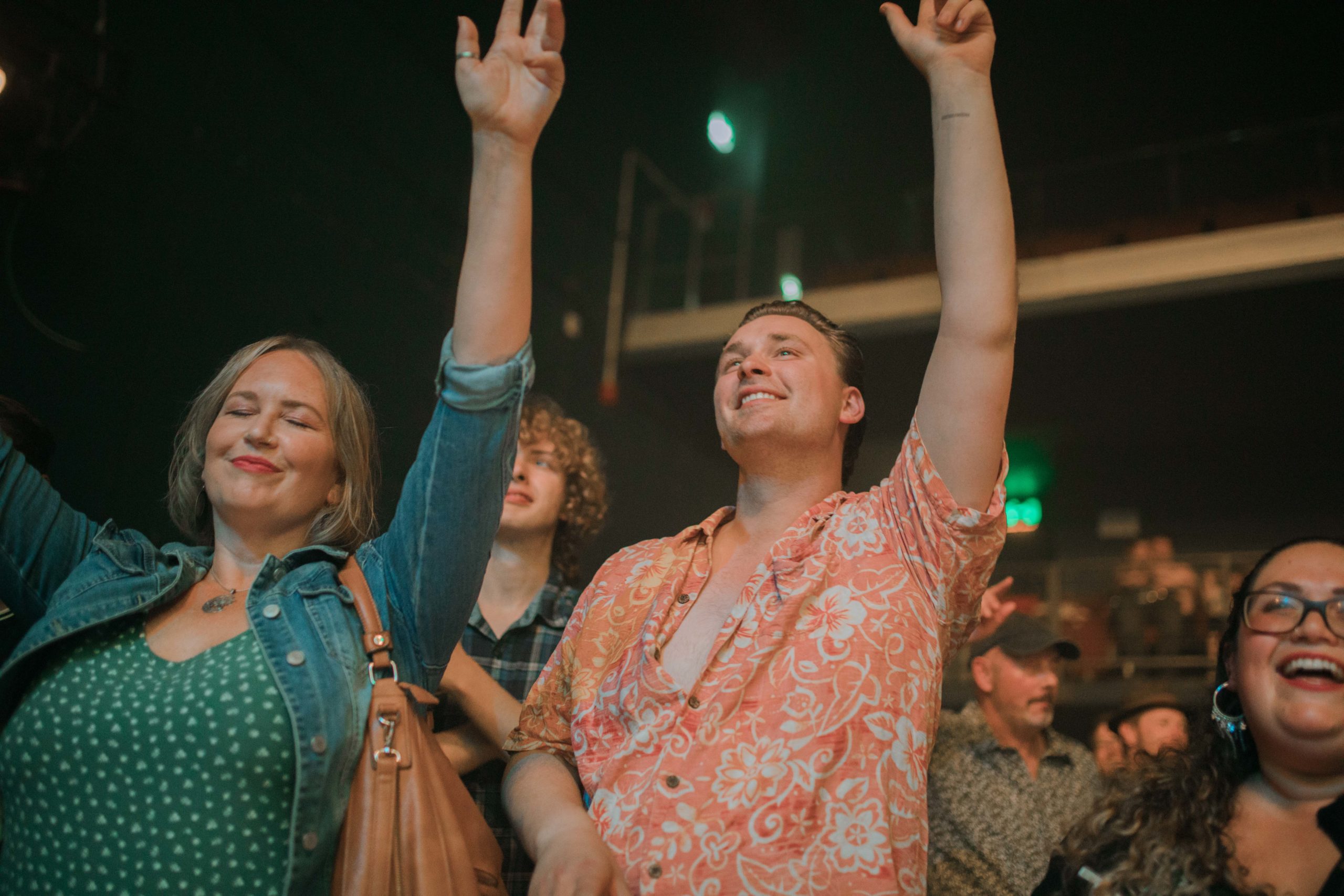 A crowd of people holding their hands up in a gig