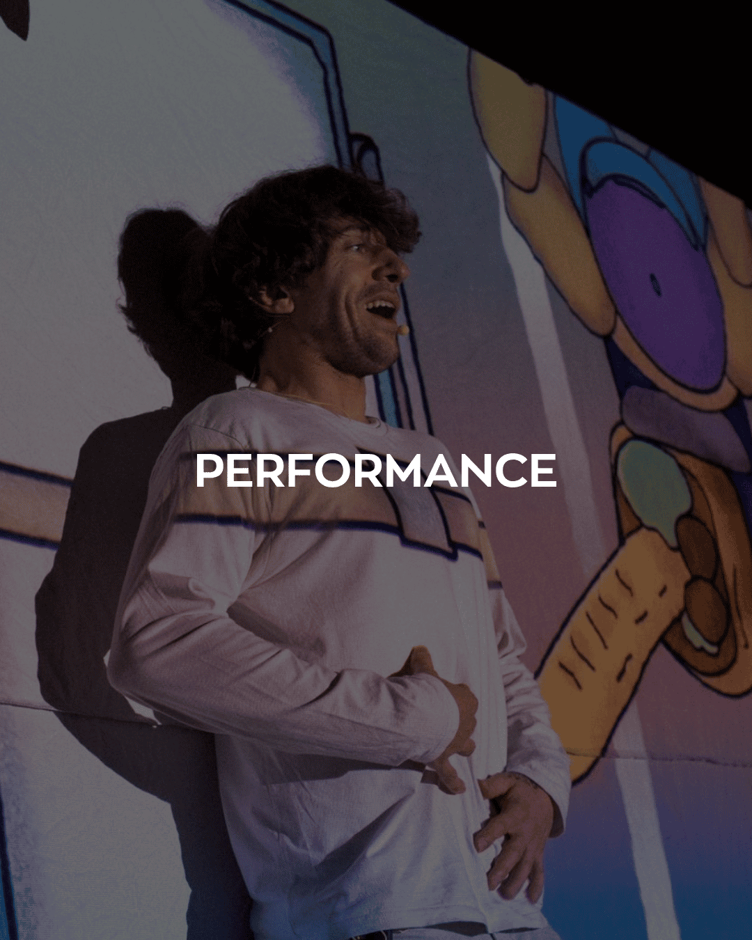 The word 'performance' over an image of a man on stage with colourful projections over him.