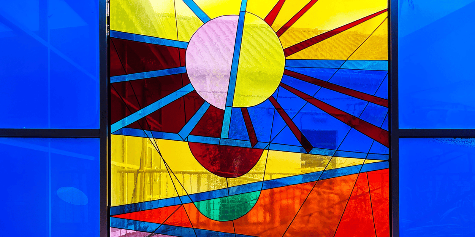 A stained glass window depicting a rising sun.